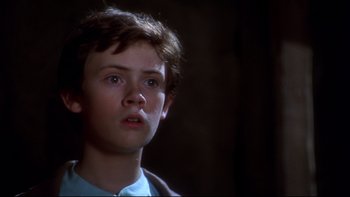 Movie still from “Frailty” (2001), directed by Bill Paxton – A young boy is looking into the distance; Close Up shot, Low angle