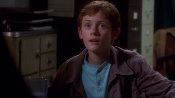 Movie still from “Frailty” (2001), directed by Bill Paxton – A young boy in a blue shirt and a brown jacket; Close Up shot, High angle