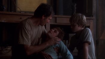 Movie still from “Frailty” (2001), directed by Bill Paxton – A man and two young boys in a living room; Medium shot, Low angle