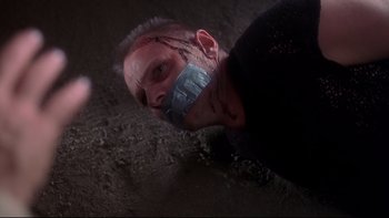Movie still from “Frailty” (2001), directed by Bill Paxton – A man with tape over his mouth and nose; Close Up shot, Overhead angle