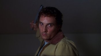 Movie still from “Frailty” (2001), directed by Bill Paxton – A man holding a knife up to his head; Close Up shot, Low angle
