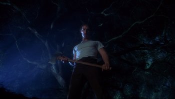 Movie still from “Frailty” (2001), directed by Bill Paxton – A man holding an axe standing in the dark; Medium shot, Low angle