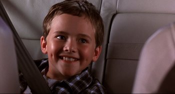 Movie still from “Freaky Friday” (2003), directed by Mark Waters – A young boy sitting in the back seat of a car; Close Up shot, High angle