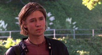 Movie still from “Freaky Friday” (2003), directed by Mark Waters – A man with long blonde hair wearing a black jacket; Close Up shot, Low angle