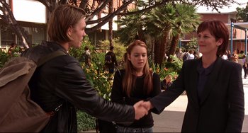 Movie still from “Freaky Friday” (2003), directed by Mark Waters – A man and a woman shaking hands while another woman looks on; Medium shot, Over the shoulder angle