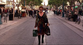 Movie still from “Freaky Friday” (2003), directed by Mark Waters – A woman walking down the street with several bags of shopping; Wide shot, Low angle