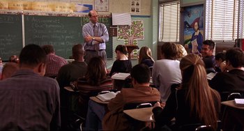 Movie still from “Freaky Friday” (2003), directed by Mark Waters – A man standing in front of a group of people; Wide shot, Over the shoulder angle