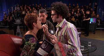 Movie still from “Freaky Friday” (2003), directed by Mark Waters – A man with a beard and glasses is holding a mirror and another man is holding a microphone and another man is holding a microphone; Medium shot, Over the shoulder angle