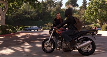 Movie still from “Freaky Friday” (2003), directed by Mark Waters – A woman is talking to a man sitting on a motorcycle; Wide shot, Over the shoulder angle