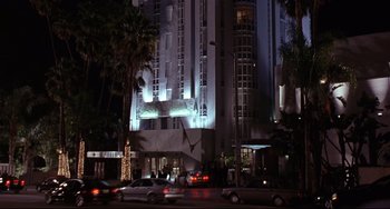 Movie still from “Freaky Friday” (2003), directed by Mark Waters – Cars driving down the street in front of a tall building at night; Extreme Wide shot, Low angle