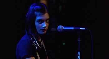 Movie still from “Freaky Friday” (2003), directed by Mark Waters – A woman is standing up with a microphone in front of her; Close Up shot, Over the shoulder angle