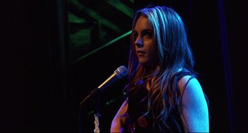 Movie still from “Freaky Friday” (2003), directed by Mark Waters – A woman with long hair standing in front of a microphone; Close Up shot, Over the shoulder angle