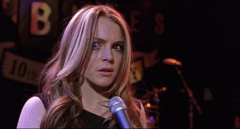 Movie still from “Freaky Friday” (2003), directed by Mark Waters – A person holding a microphone on a stage; Close Up shot, Over the shoulder angle