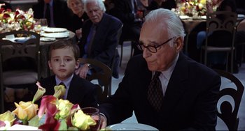 Movie still from “Freaky Friday” (2003), directed by Mark Waters – An older man sitting at a table with a young boy; Medium shot, Over the shoulder angle