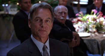 Movie still from “Freaky Friday” (2003), directed by Mark Waters – A man in a suit and tie in front of other men; Close Up shot, Over the shoulder angle