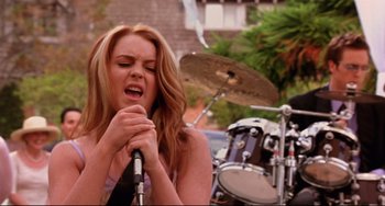 Movie still from “Freaky Friday” (2003), directed by Mark Waters – A woman singing into a microphone while standing in front of a drum set; Medium shot, Low angle