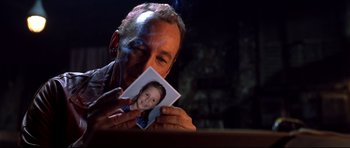Movie still from “Freddy vs. Jason” (2003), directed by Ronny Yu – A man holding up a picture of a child; Close Up shot, Over the shoulder angle
