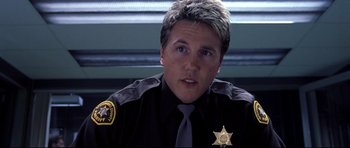 Movie still from “Freddy vs. Jason” (2003), directed by Ronny Yu – A man in a sheriff's uniform is looking at the camera; Close Up shot, Low angle