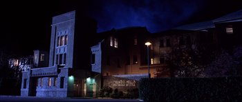 Movie still from “Freddy vs. Jason” (2003), directed by Ronny Yu – A building that is lit up at night time; Extreme Wide shot, Low angle