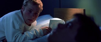 Movie still from “Freddy vs. Jason” (2003), directed by Ronny Yu – A young boy laying in a bed looking at a picture; Close Up shot, Over the shoulder angle
