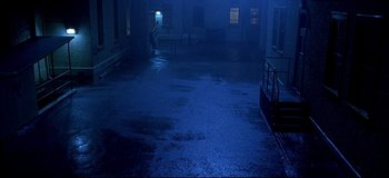 Movie still from “Freddy vs. Jason” (2003), directed by Ronny Yu – A dark room with a person standing on the steps; Extreme Wide shot, High angle