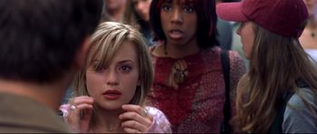 Movie still from “Freddy vs. Jason” (2003), directed by Ronny Yu – Two women are standing together in a crowd of people; Close Up shot, Over the shoulder angle