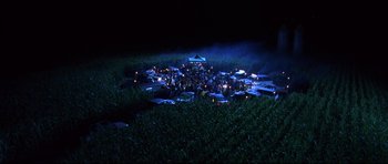 Movie still from “Freddy vs. Jason” (2003), directed by Ronny Yu – A large group of people gathered in a field at night; Extreme Wide shot, High angle