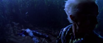 Movie still from “Freddy vs. Jason” (2003), directed by Ronny Yu – A man in a camouflage jacket looking at a dead body in the woods; Close Up shot, Over the shoulder angle