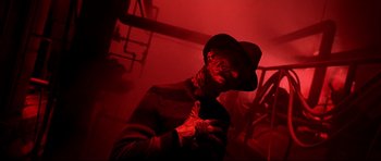 Movie still from “Freddy vs. Jason” (2003), directed by Ronny Yu – A man in a hat and a sweater is standing in a room; Close Up shot, Low angle