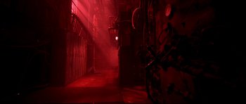 Movie still from “Freddy vs. Jason” (2003), directed by Ronny Yu – A red light shines in the dark of a building; Extreme Wide shot, High angle
