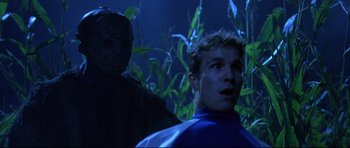 Movie still from “Freddy vs. Jason” (2003), directed by Ronny Yu – A man in a blue shirt and a man in a black mask; Medium shot, Low angle