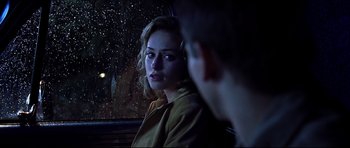 A woman sitting in the back of a car at night