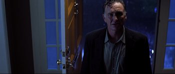 Movie still from “Freddy vs. Jason” (2003), directed by Ronny Yu – A man standing in front of an open door at night; Medium shot, Low angle