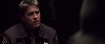 Movie still from “Freddy vs. Jason” (2003), directed by Ronny Yu – A man in a police uniform looking at the camera; Close Up shot, Over the shoulder angle