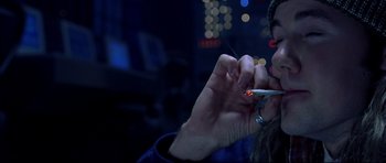 Movie still from “Freddy vs. Jason” (2003), directed by Ronny Yu – A person is smoking a cigarette in a dark room; Close Up shot, Overhead angle