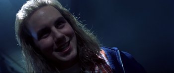Movie still from “Freddy vs. Jason” (2003), directed by Ronny Yu – A person with long hair smiling; Close Up shot, Over the shoulder angle