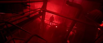 Movie still from “Freddy vs. Jason” (2003), directed by Ronny Yu – A man is standing in a dark room with red lights; Extreme Wide shot, High angle