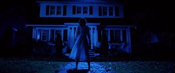 Movie still from “Freddy vs. Jason” (2003), directed by Ronny Yu – A woman standing in front of a house at night; Wide shot, Low angle