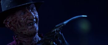 Movie still from “Freddy vs. Jason” (2003), directed by Ronny Yu – A person wearing a hat and holding a gun; Close Up shot, Low angle