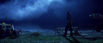 Movie still from “Freddy vs. Jason” (2003), directed by Ronny Yu – A man walking on the grass in front of a cloudy sky; Wide shot, Low angle