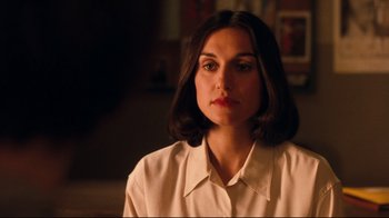 A woman in a white shirt is sitting down
