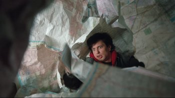Movie still from “Freddy's Dead: The Final Nightmare” (1991), directed by Rachel Talalay – A man is looking through a hole in a map; Close Up shot, Overhead angle