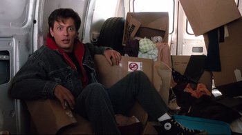 Movie still from “Freddy's Dead: The Final Nightmare” (1991), directed by Rachel Talalay – A man sitting in a chair with boxes in front of him; Medium shot, Low angle