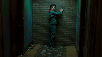 Movie still from “Freddy's Dead: The Final Nightmare” (1991), directed by Rachel Talalay – A young man leaning against a brick wall; Wide shot, Overhead angle