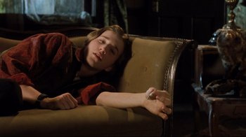 Movie still from “Freddy's Dead: The Final Nightmare” (1991), directed by Rachel Talalay – A woman laying on a couch with her arm resting on the couch; Medium shot, High angle
