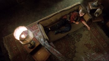 Movie still from “Freddy's Dead: The Final Nightmare” (1991), directed by Rachel Talalay – A person laying on a couch in a living room; Wide shot, Overhead angle