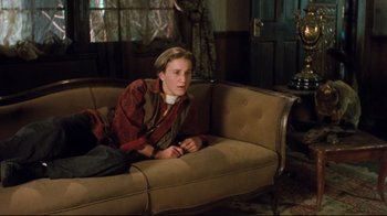 Movie still from “Freddy's Dead: The Final Nightmare” (1991), directed by Rachel Talalay – A woman sitting on top of a couch in a living room; Medium shot, High angle