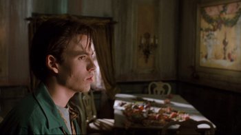 Movie still from “Freddy's Dead: The Final Nightmare” (1991), directed by Rachel Talalay – A man sitting in front of a table with food on top of it; Close Up shot, Low angle