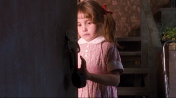 Movie still from “Freddy's Dead: The Final Nightmare” (1991), directed by Rachel Talalay – A little girl in a pink dress holding a door knob; Close Up shot, High angle