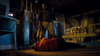 Movie still from “Freddy's Dead: The Final Nightmare” (1991), directed by Rachel Talalay – A man standing next to a man laying on the ground; Medium shot, Low angle